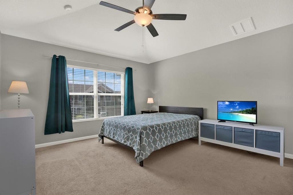 10228 Red Currant Court Riverview, FL 33578 - Photo 27 of 37 a bedroom with a bed and a chandelier