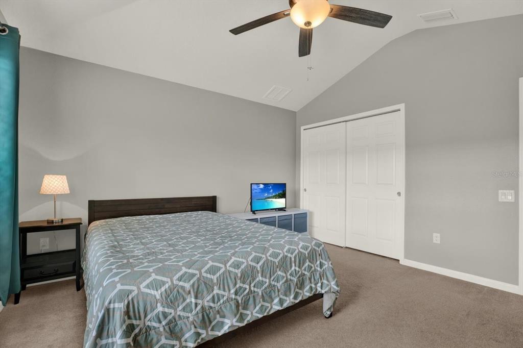 10228 Red Currant Court Riverview, FL 33578 - Photo 28 of 37 a bedroom with a large bed and a chandelier