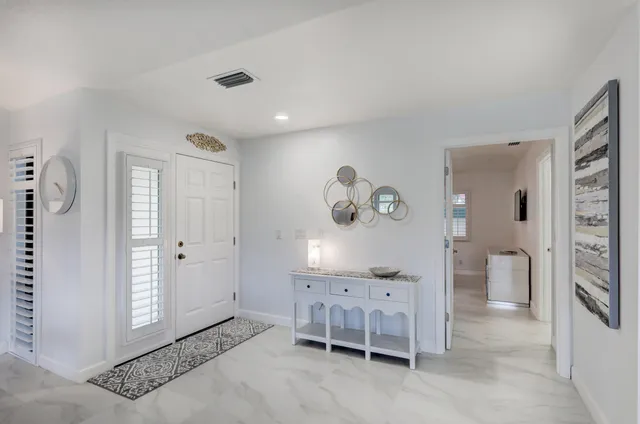 a front view of a house with a yard and potted plants