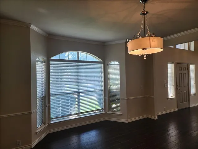 a room with wooden floor and windows