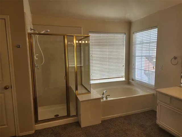 an empty room with windows fireplace and wooden floor