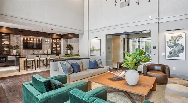 a living room with furniture a flat screen tv and a floor to ceiling window
