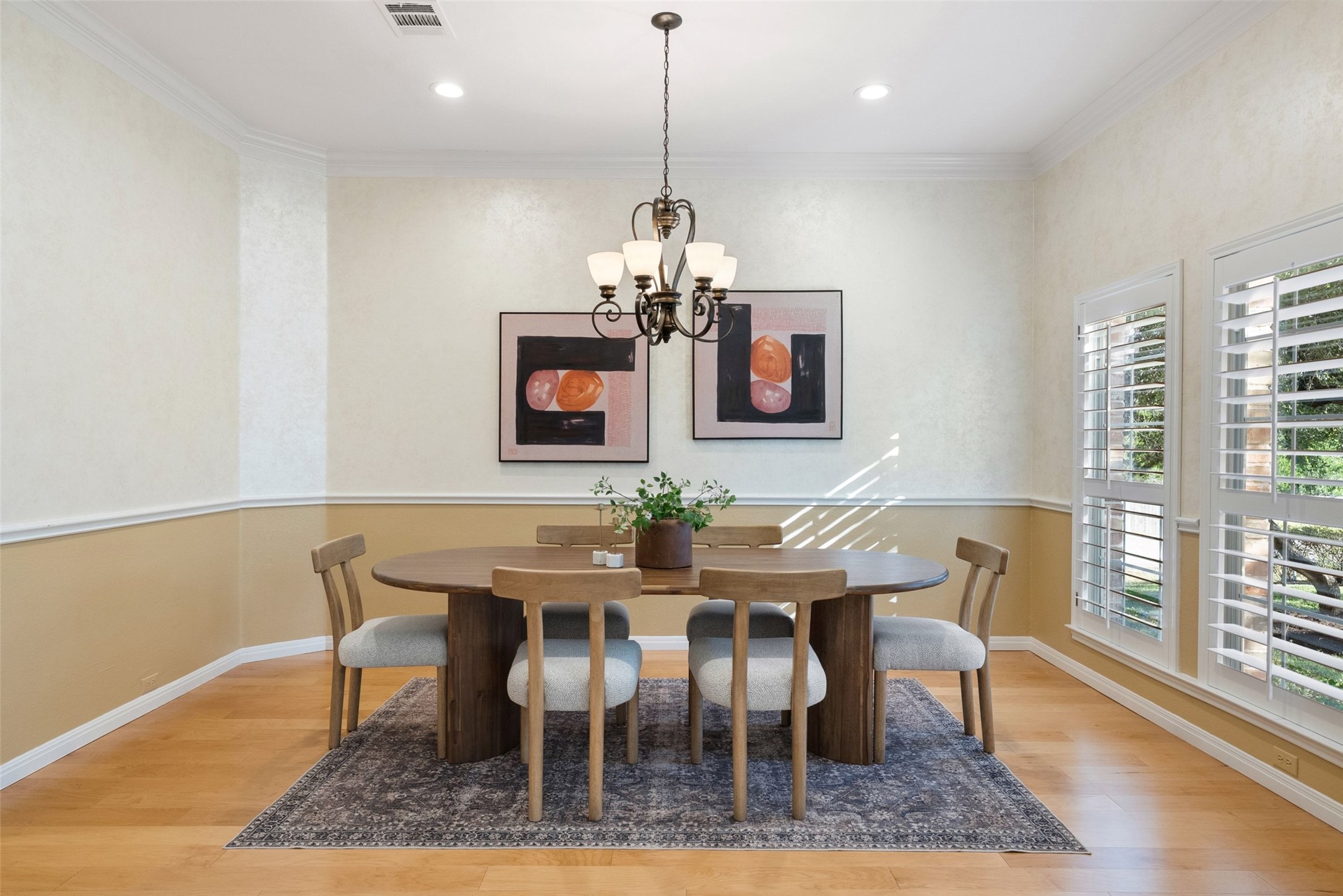 8215 Dark Ridge Cove Austin, TX 78737 - Photo 7 of 40 The elegant dining space by the entry features crown molding, custom wall treatments, wood flooring, and ample natural light from two large windows.