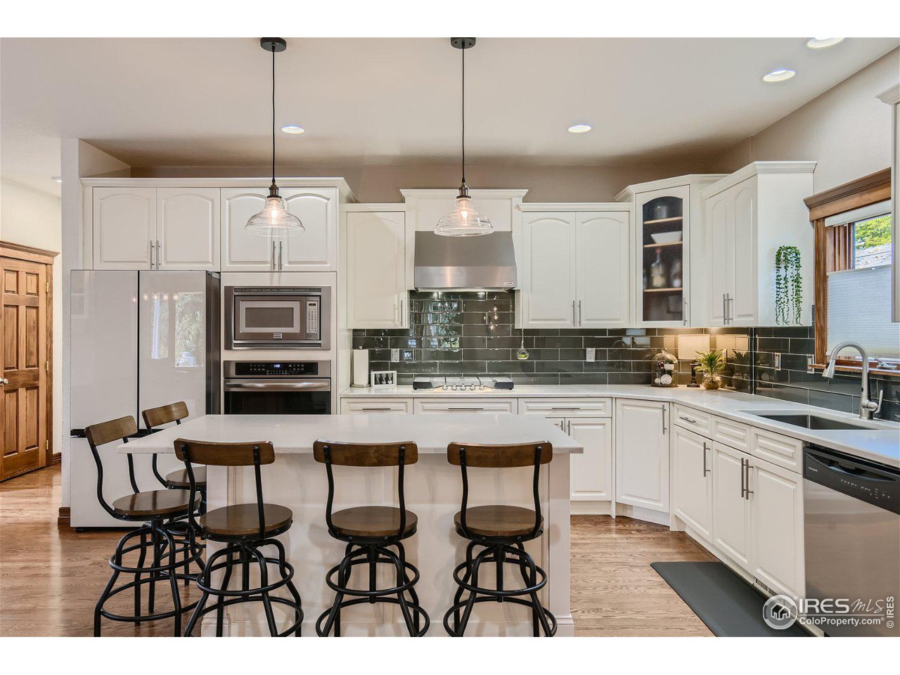 321 North Meldrum Street Fort Collins, CO 80521 - Photo 11 of 40 a kitchen with stainless steel appliances kitchen island granite countertop a stove a sink and a refrigerator