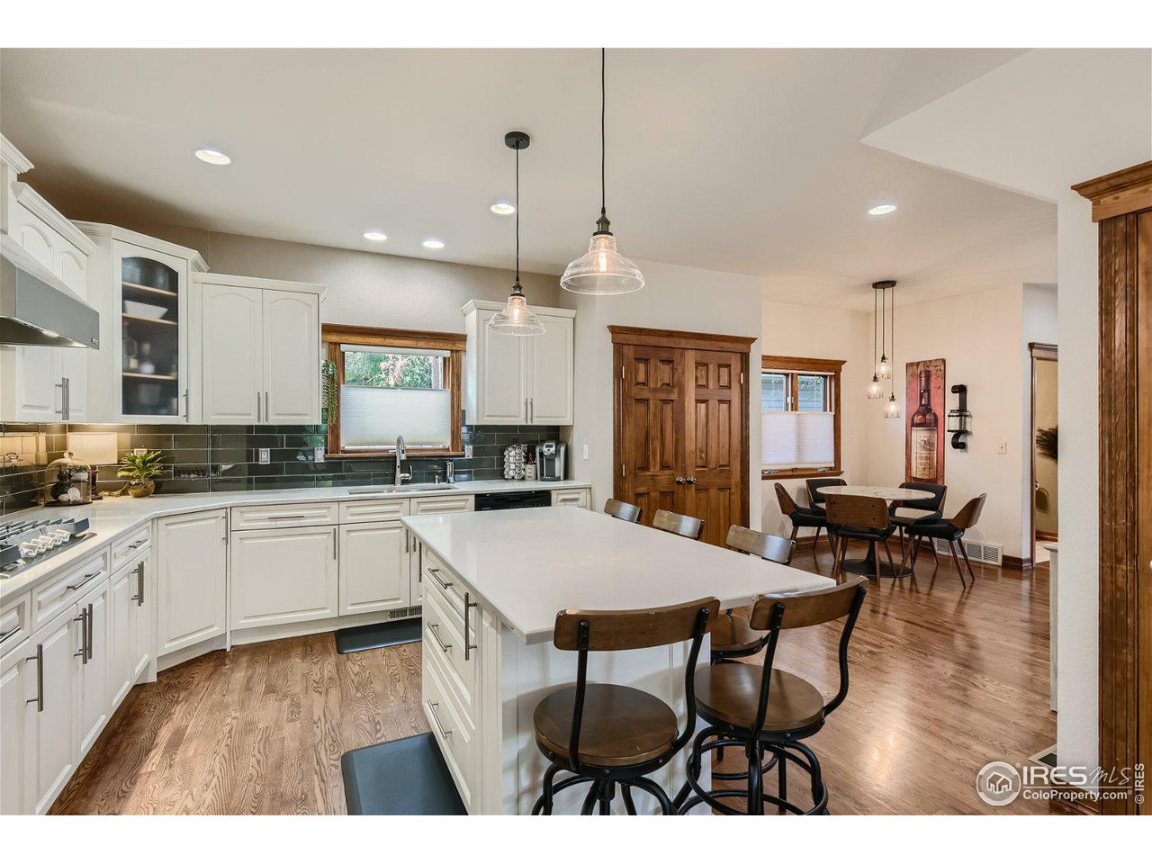 321 North Meldrum Street Fort Collins, CO 80521 - Photo 7 of 40 a kitchen with stainless steel appliances kitchen island granite countertop a stove a sink a dining table and chairs