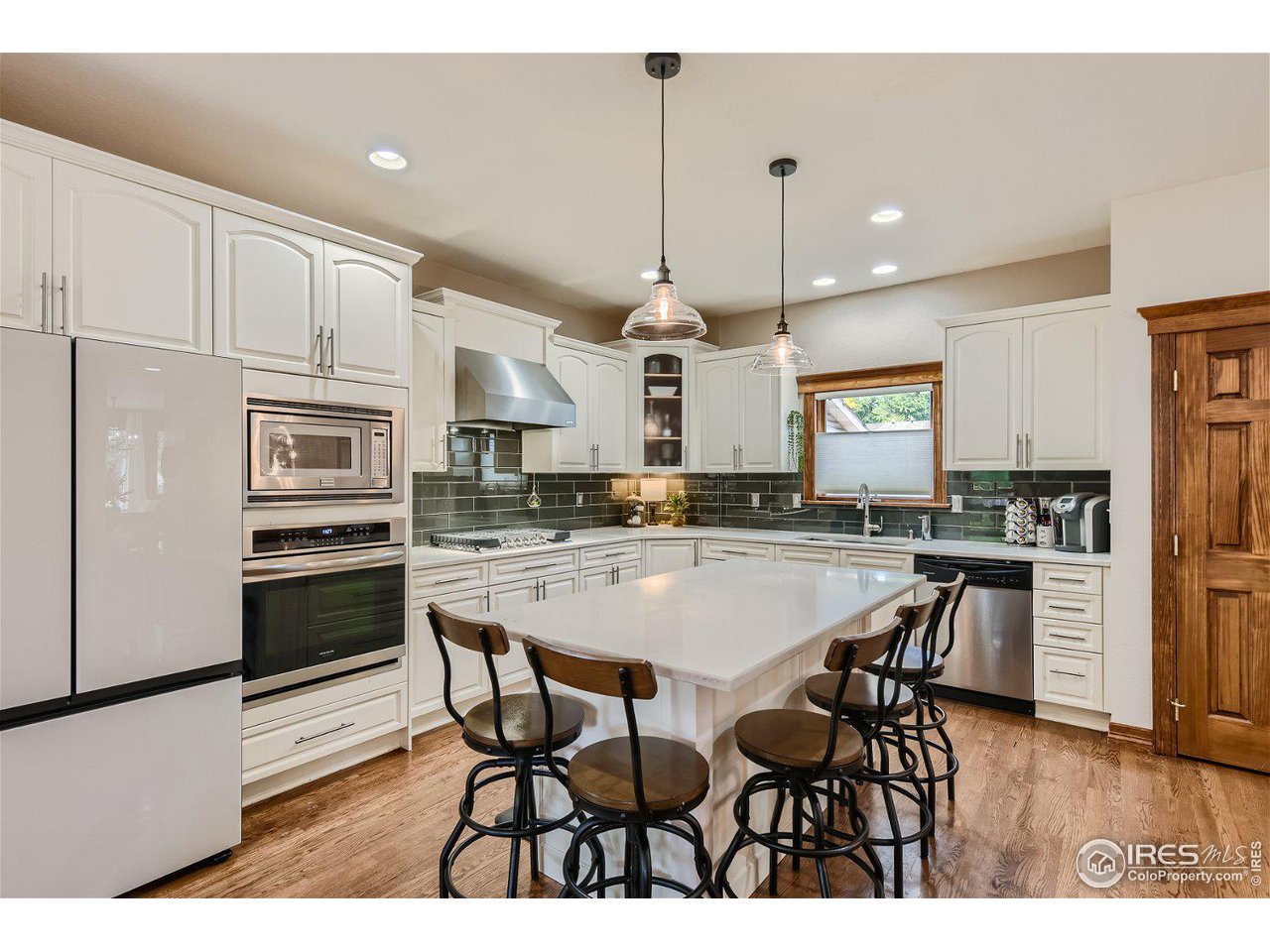 321 North Meldrum Street Fort Collins, CO 80521 - Photo 8 of 40 a kitchen with stainless steel appliances kitchen island granite countertop a kitchen island a stove a table and chairs