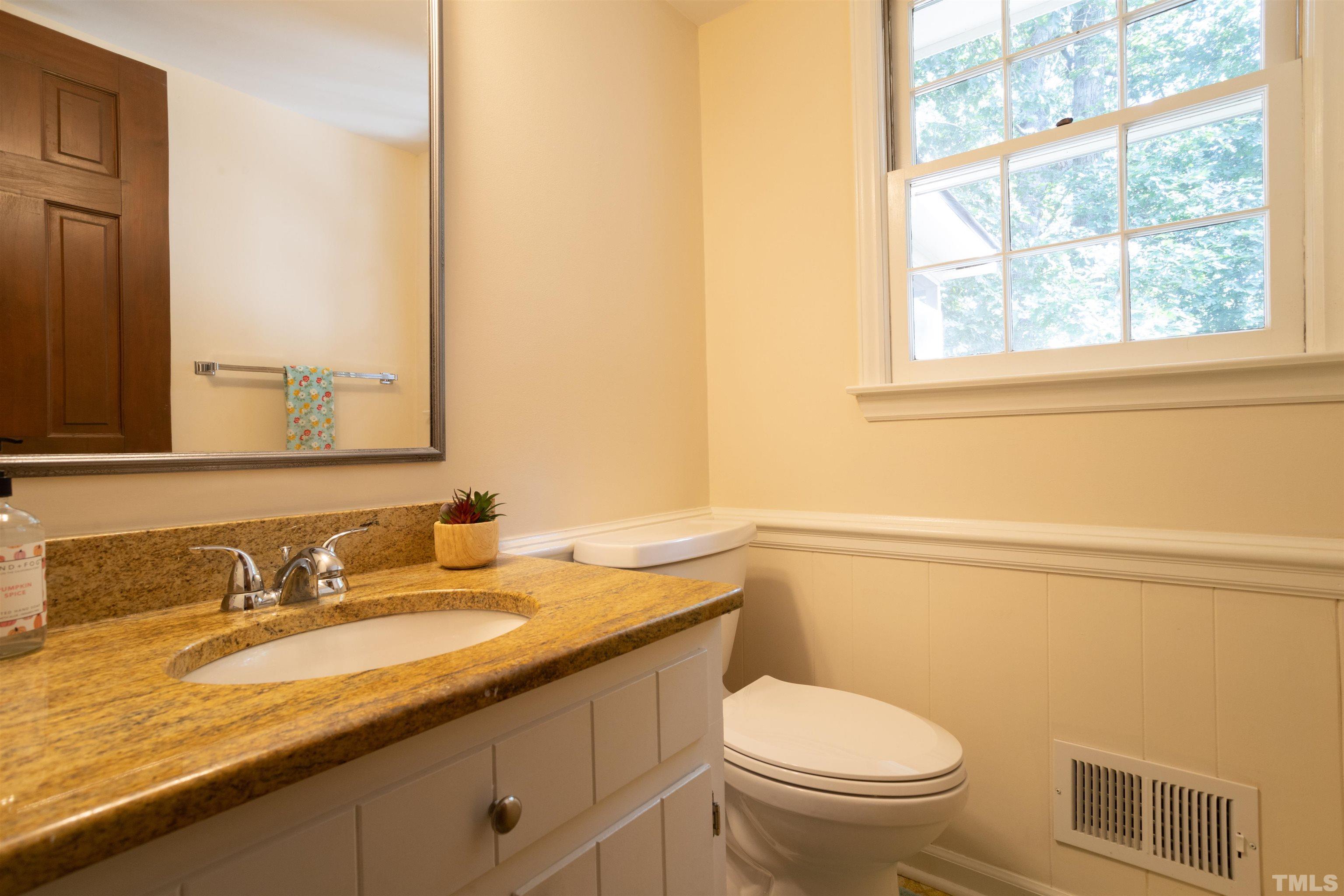 4324 Oak Park Road Raleigh, NC 27612 - Photo 14 of 33 a bathroom with a granite countertop toilet a sink and a window