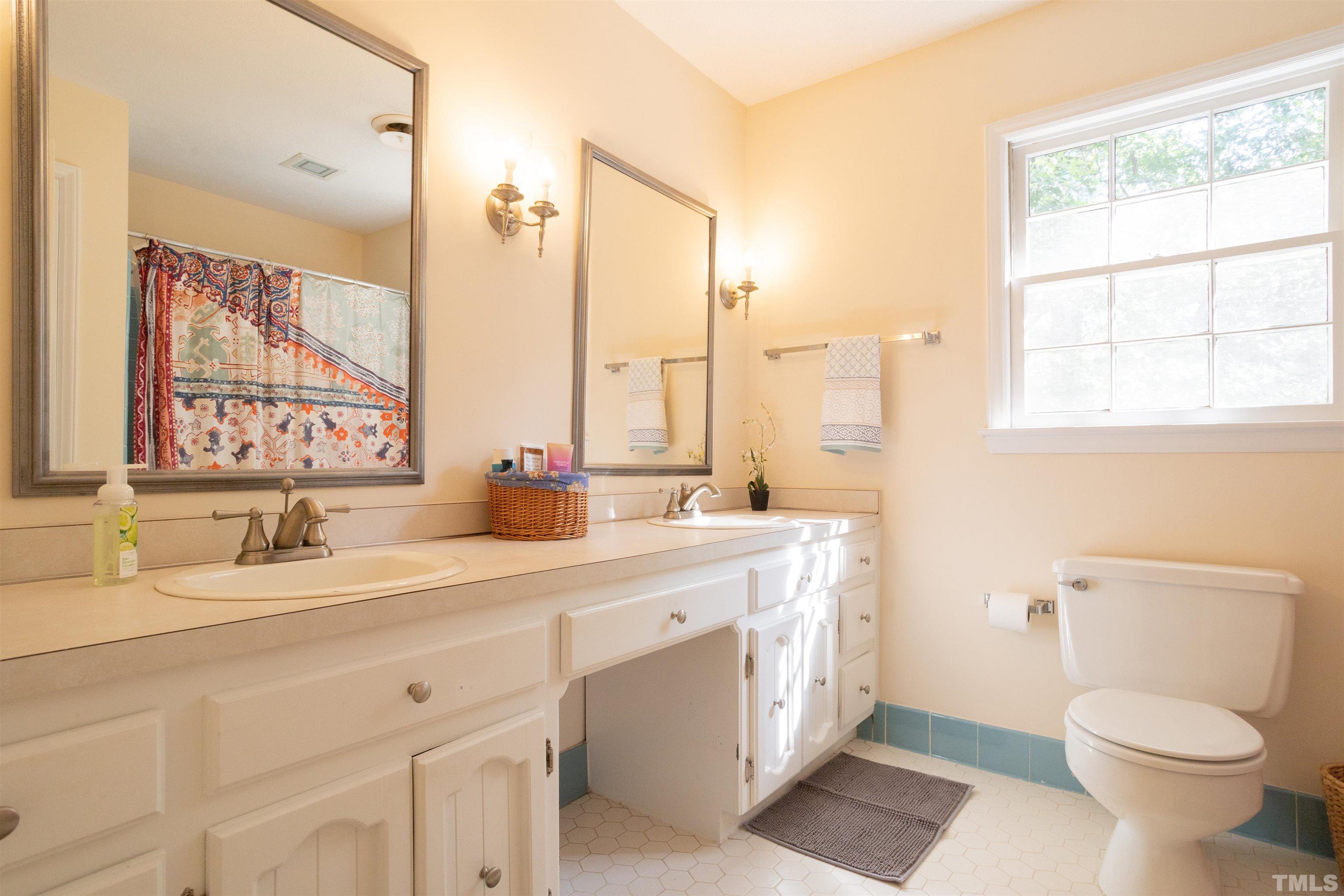 4324 Oak Park Road Raleigh, NC 27612 - Photo 24 of 33 a bathroom with a double vanity sink toilet and a mirror