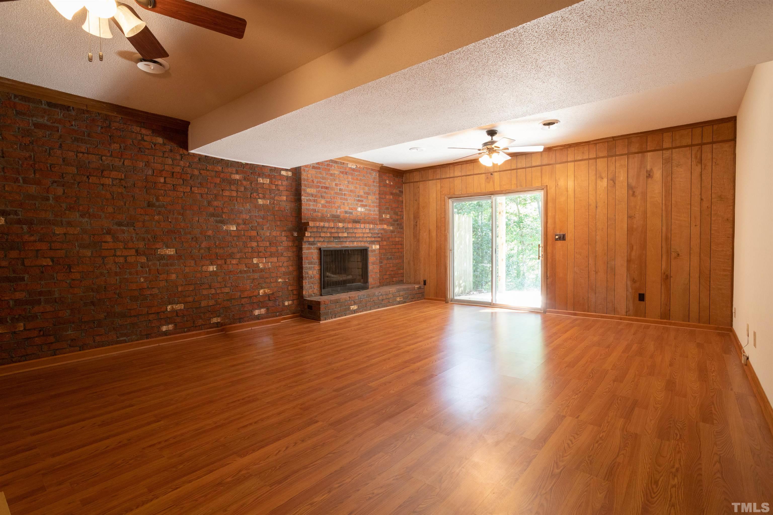4324 Oak Park Road Raleigh, NC 27612 - Photo 27 of 33 an empty room with windows fireplace and wooden floor