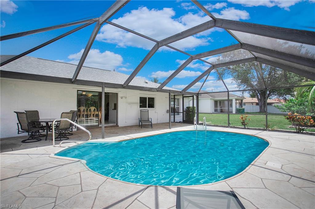 4736 25th Avenue Southwest Naples, FL 34116 - Photo 16 of 22 a view of a backyard with table and chairs under an umbrella
