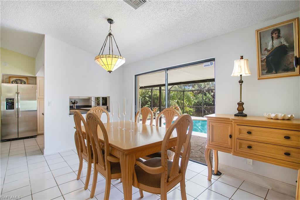 4736 25th Avenue Southwest Naples, FL 34116 - Photo 5 of 22 a dining room with furniture a chandelier and wooden floor