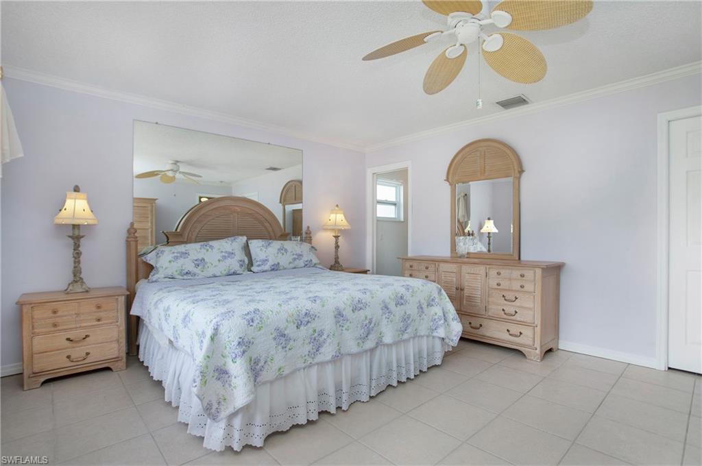 4736 25th Avenue Southwest Naples, FL 34116 - Photo 8 of 22 a bedroom with a bed and a chandelier