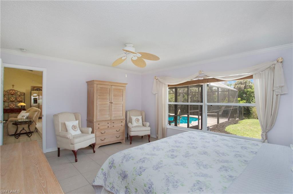 4736 25th Avenue Southwest Naples, FL 34116 - Photo 9 of 22 a bedroom with a bed and large glass window