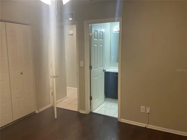 an empty room with wooden floor and mirror