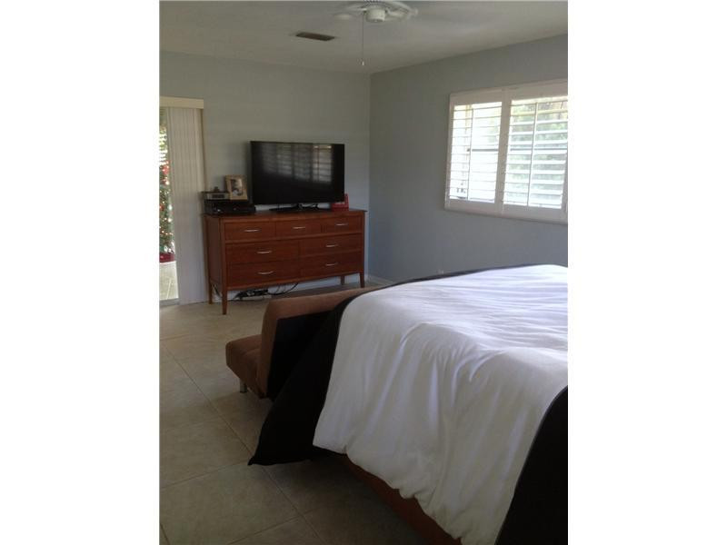 399 Southwest 12th Avenue Boca Raton, FL 33486 - Photo 13 of 19 a bedroom with a bed and a flat screen tv