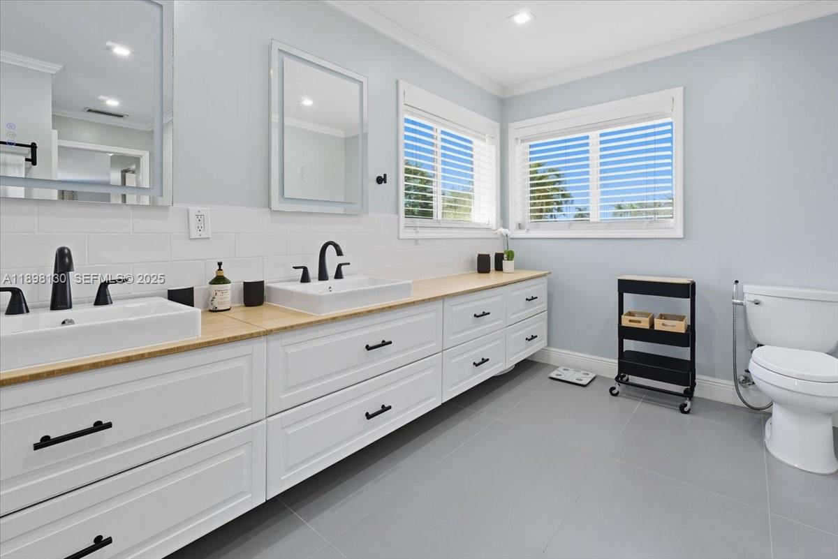 347 Fairmont Road Weston, FL 33326 - Photo 25 of 42 a spacious bathroom with double sink a mirror a toilet and a window