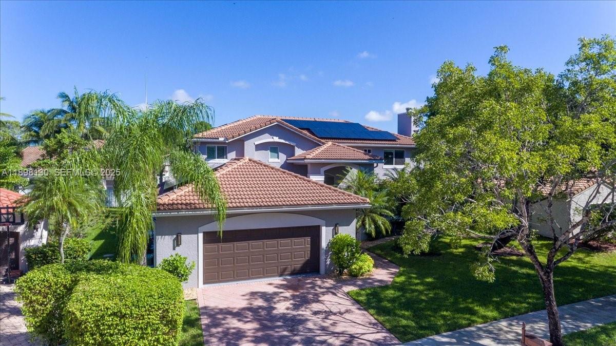 347 Fairmont Road Weston, FL 33326 - Photo 3 of 42 a front view of a house with a garden
