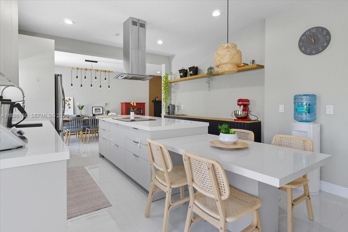 347 Fairmont Road Weston, FL 33326 - Photo 6 of 42 a kitchen with stainless steel appliances kitchen island granite countertop a table chairs and a refrigerator