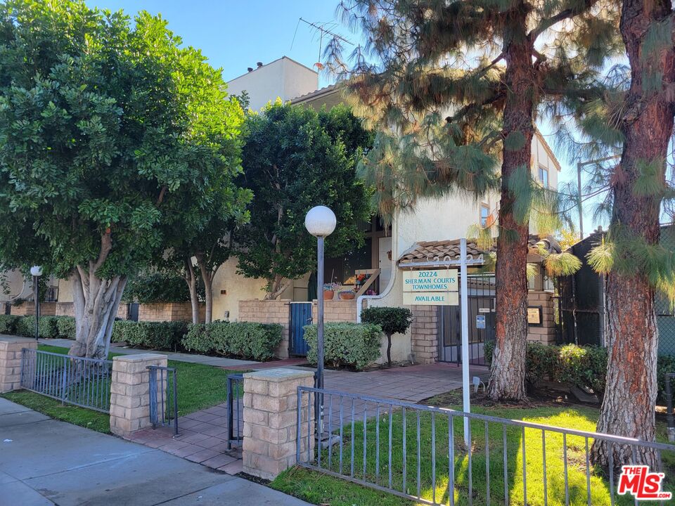 a front view of a house with a garden and a tree