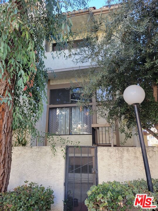 20224 Sherman Way, Unit 27 Canoga Park, CA 91306 - Photo 3 of 13 a front view of a house with a yard