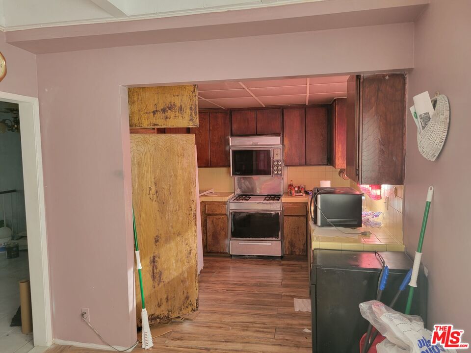 20224 Sherman Way, Unit 27 Canoga Park, CA 91306 - Photo 8 of 13 a kitchen with a refrigerator sink and stove top oven