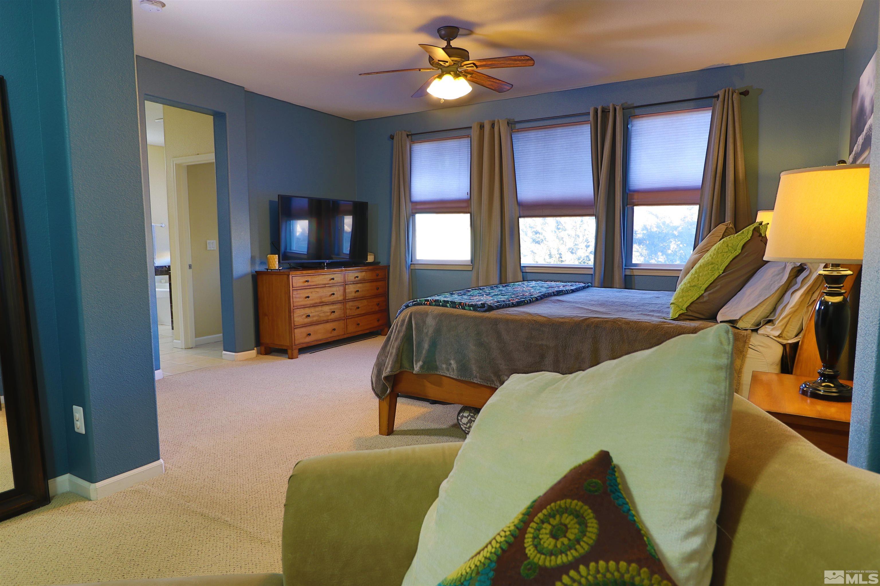 2491 Spring Flower Drive Reno, NV 89521 - Photo 11 of 19 a bedroom with a bed and a chandelier