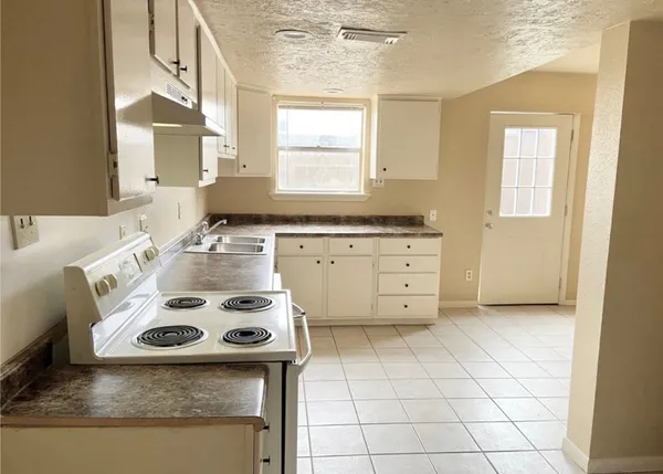a kitchen with a stove a sink and a refrigerator