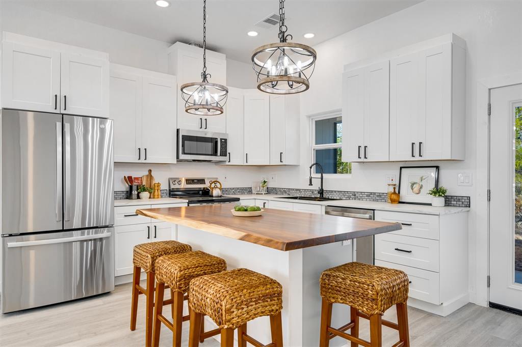 260 Private Road Sumner, TX 75486 - Photo 7 of 23 a kitchen with stainless steel appliances granite countertop a refrigerator a stove a sink dishwasher a dining table and chairs with wooden floor