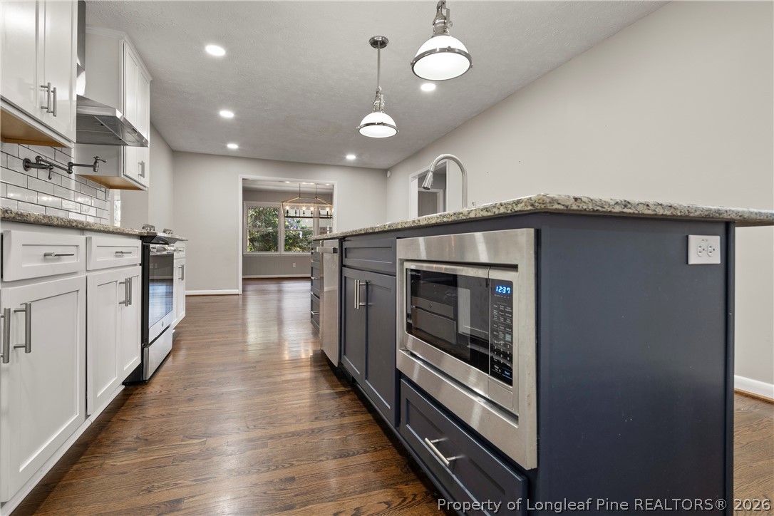4196 Cliffdale Road Fayetteville, NC 28303 - Photo 13 of 38 a kitchen with stainless steel appliances granite countertop a stove and a refrigerator