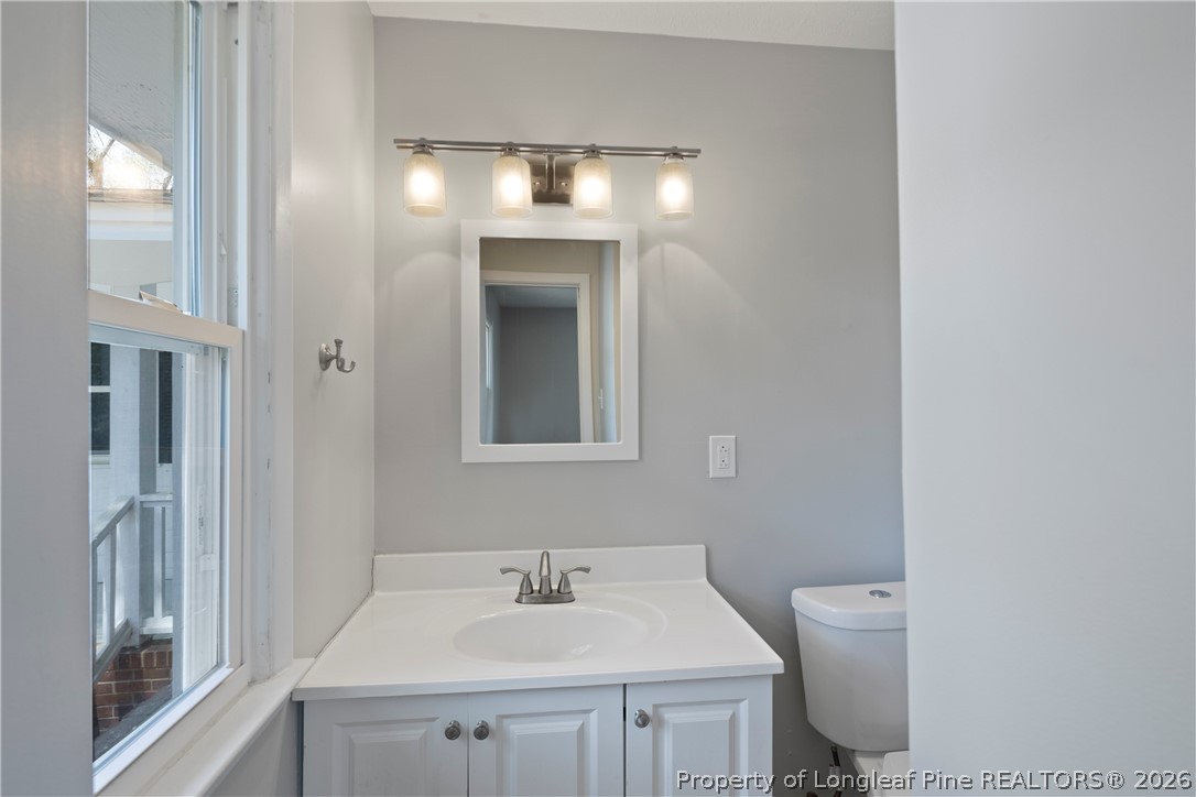 4196 Cliffdale Road Fayetteville, NC 28303 - Photo 29 of 38 a bathroom with a sink toilet and mirror