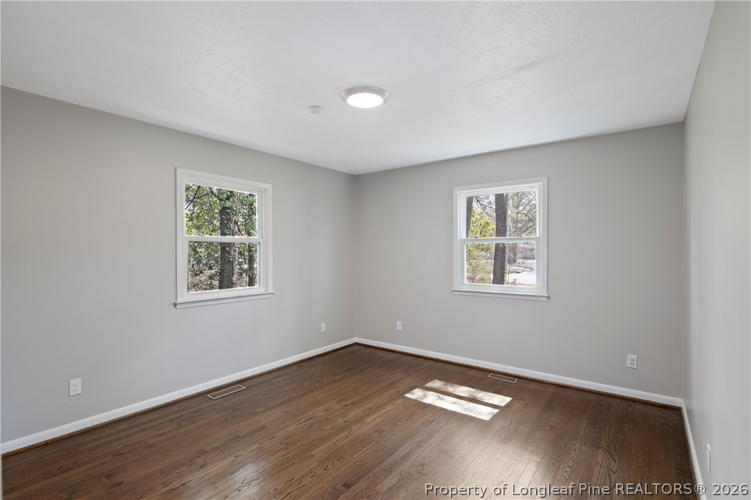 4196 Cliffdale Road Fayetteville, NC 28303 - Photo 32 of 38 a view of an empty room with wooden floor and a window