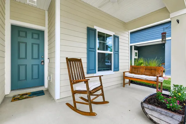 a view of a hallway with wooden floor and a bathroom