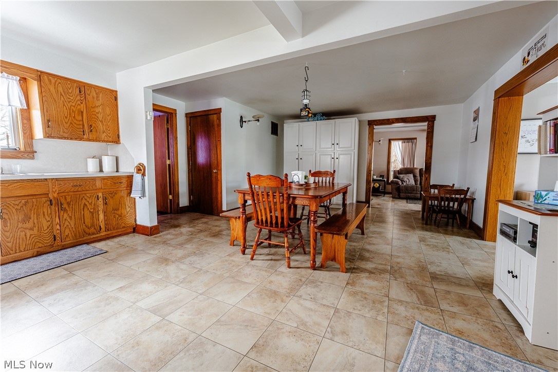 16350 Nauvoo Road Middlefield, OH 44062 - Photo 10 of 50 Dining area featuring plenty of natural light, light tile patterned floors, and beam ceiling