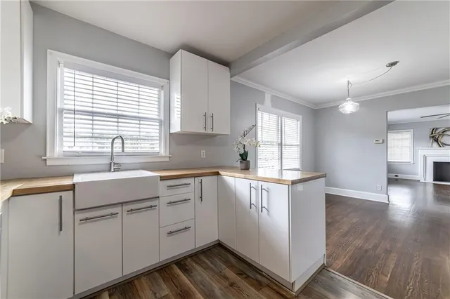 a kitchen with white cabinets and wooden floors