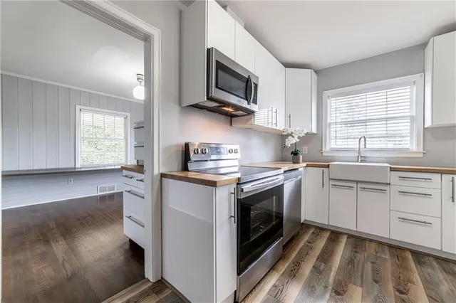 a kitchen with stainless steel appliances granite countertop a stove a sink and a microwave