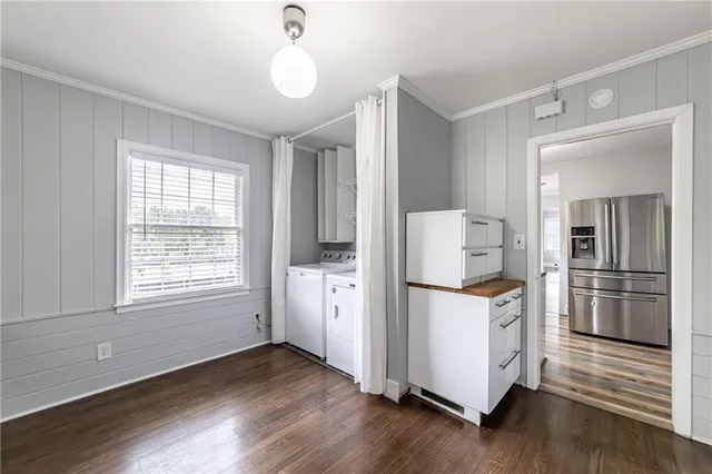 a kitchen with a refrigerator a stove and wooden floor