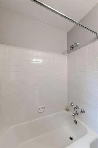 a bathroom with a white bath tub and a sink