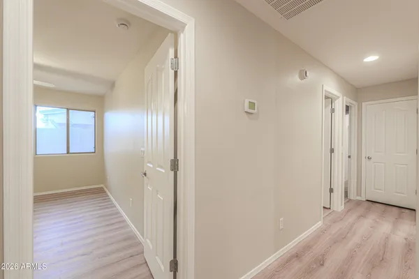 a view of a hallway with wooden floor and closet area