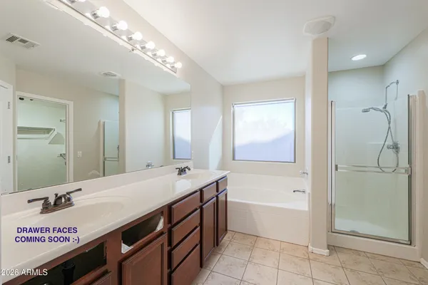 a bathroom with a tub a sink and a mirror
