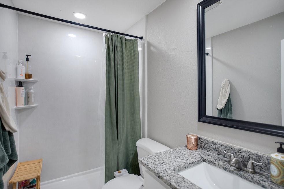 4029 Knox Street Fort Worth, TX 76119 - Photo 15 of 28 a bathroom with a granite countertop sink and a mirror