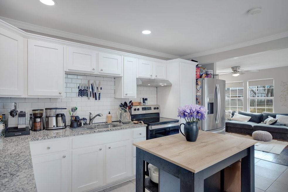 4029 Knox Street Fort Worth, TX 76119 - Photo 7 of 28 a kitchen with a stove a sink dishwasher and a refrigerator with wooden cabinets