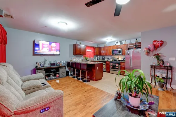 a living room with furniture kitchen and a flat screen tv