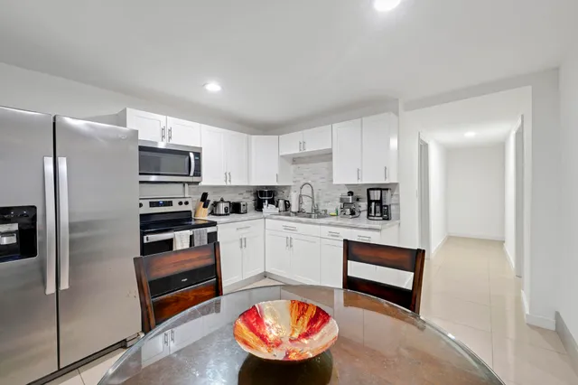 a kitchen with stainless steel appliances granite countertop a refrigerator sink and stove