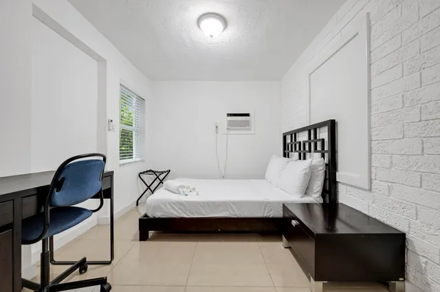 a bedroom with a bed a desk and chair