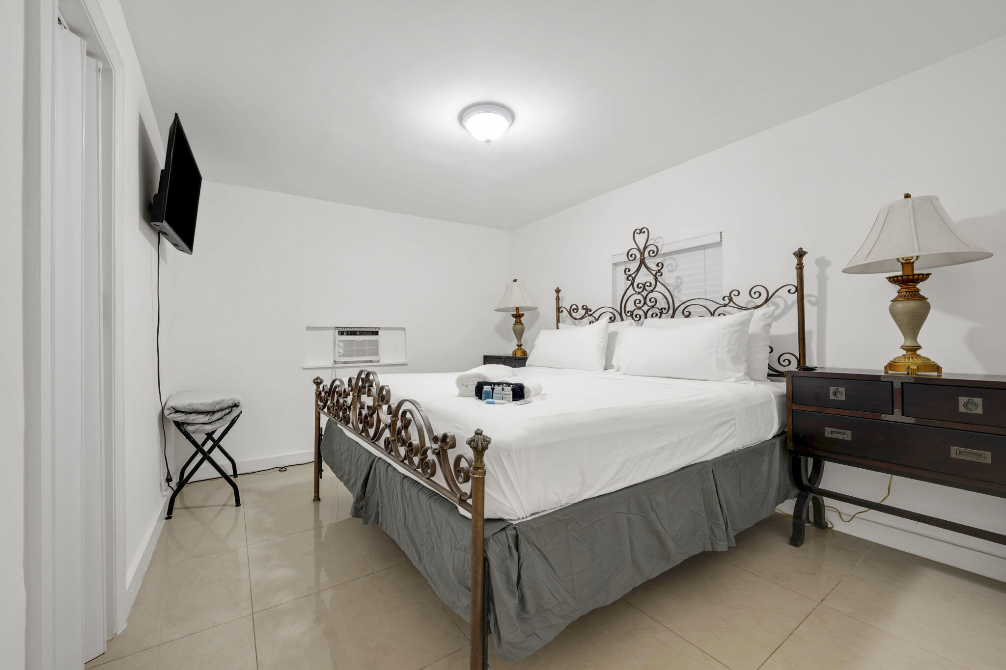 2365 Northwest 68th Street Miami, FL 33147 - Photo 16 of 22 a bedroom with a bed and a flat tv screen on the dresser