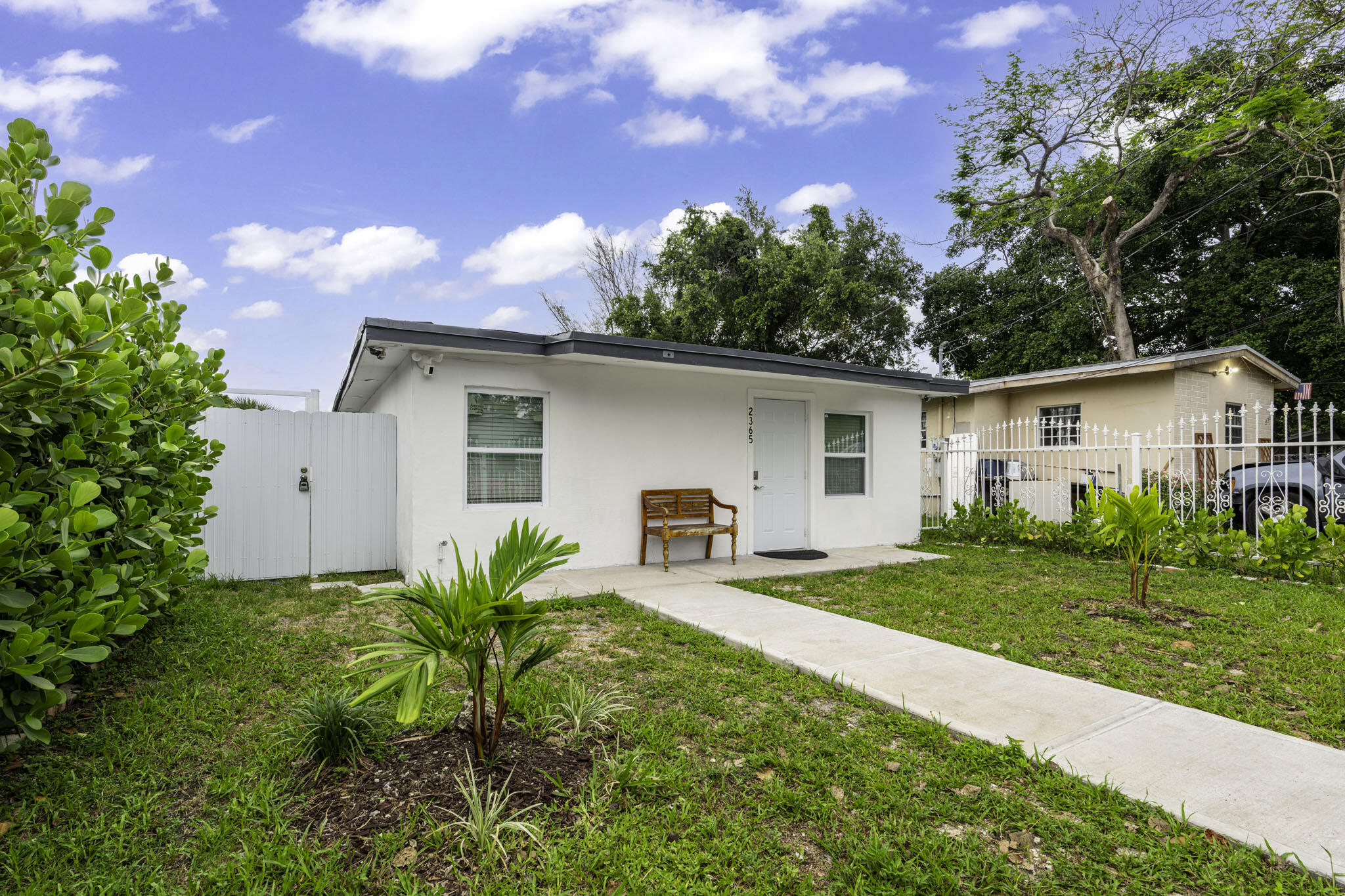 2365 Northwest 68th Street Miami, FL 33147 - Photo 2 of 22 a view of a house with a yard and potted plants