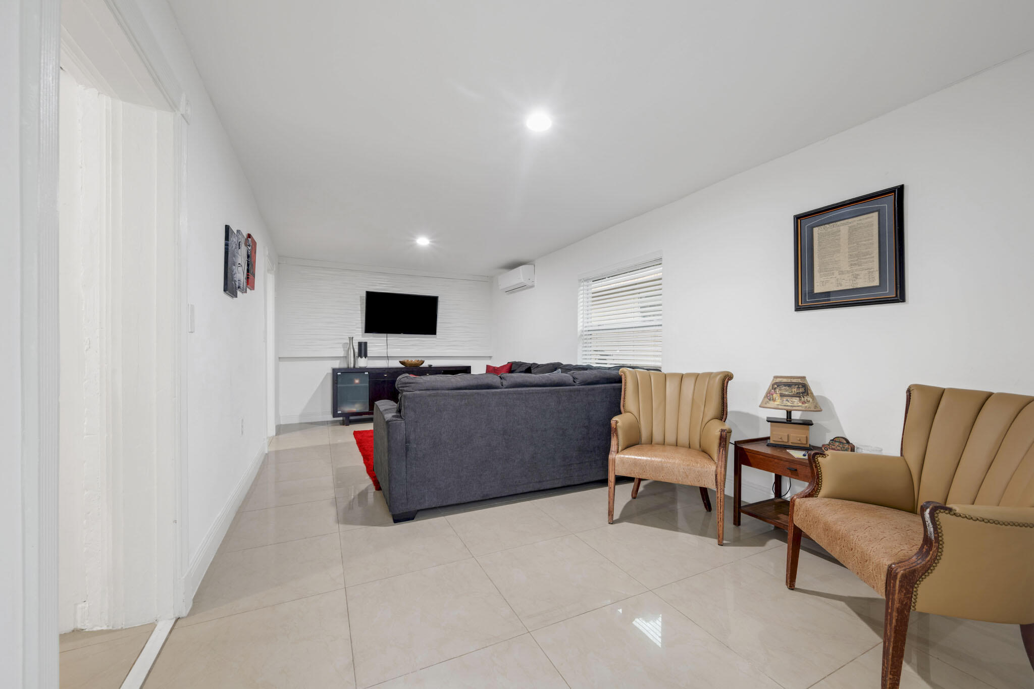 2365 Northwest 68th Street Miami, FL 33147 - Photo 4 of 22 a living room with furniture and a flat screen tv