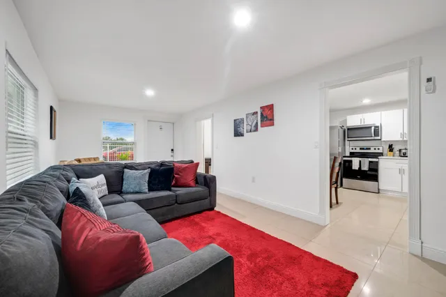 a living room with furniture and kitchen view