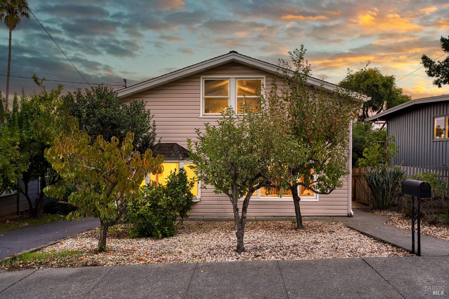 a yellow house with trees in front of it