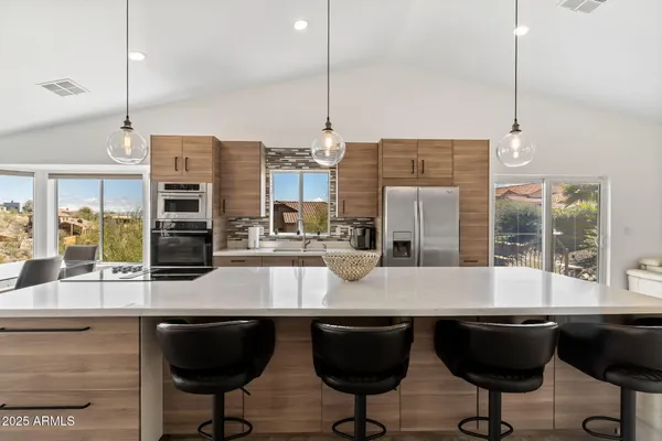 a living room with stainless steel appliances kitchen island granite countertop a couch and cabinets